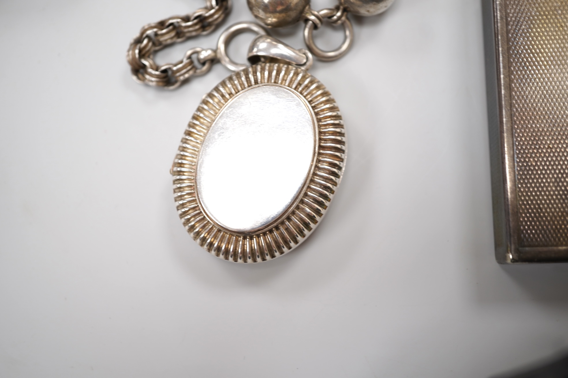 An early 20th century white metal oval locket, 40mm, on a silver chain, a silver plated Dunhill lighter, in Dunhill box, a white metal cased manual wind wrist watch and a tortoiseshell purse.